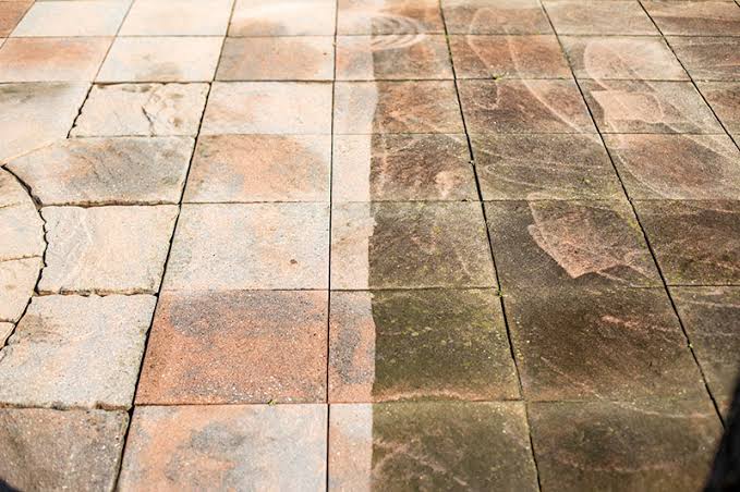 Terras- en opritbestrating voor en na reiniging: links schoon en fris, rechts groene aanslag en vuil