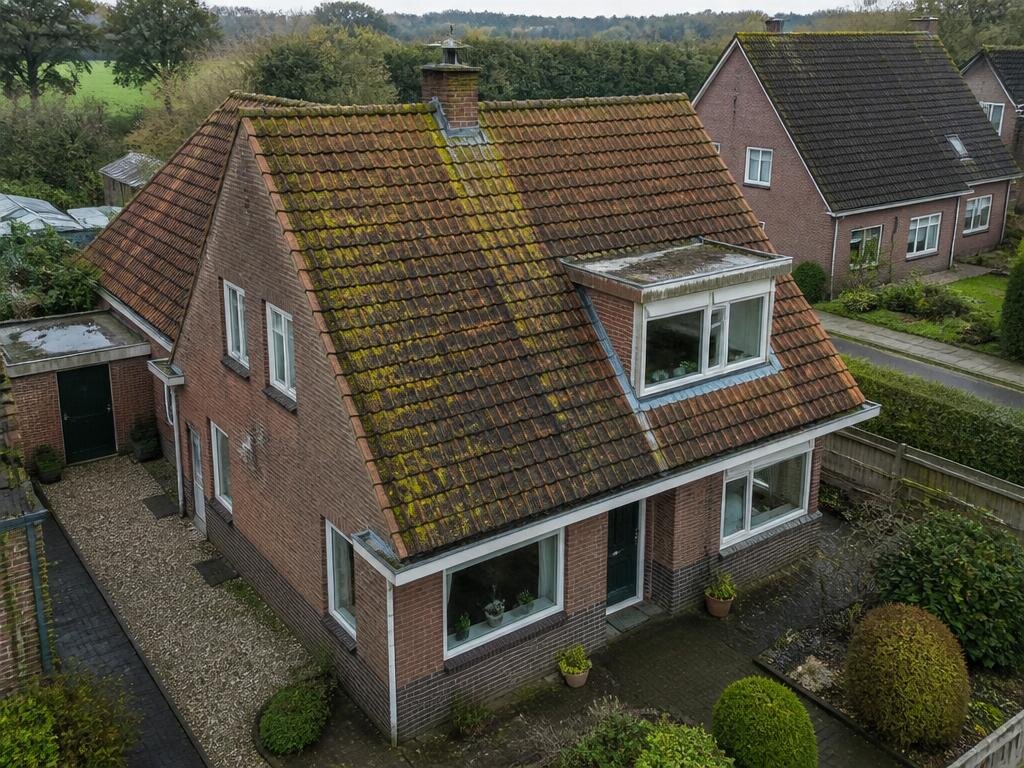 Dak van een Nederlandse woning voor reiniging, bedekt met mos en algen